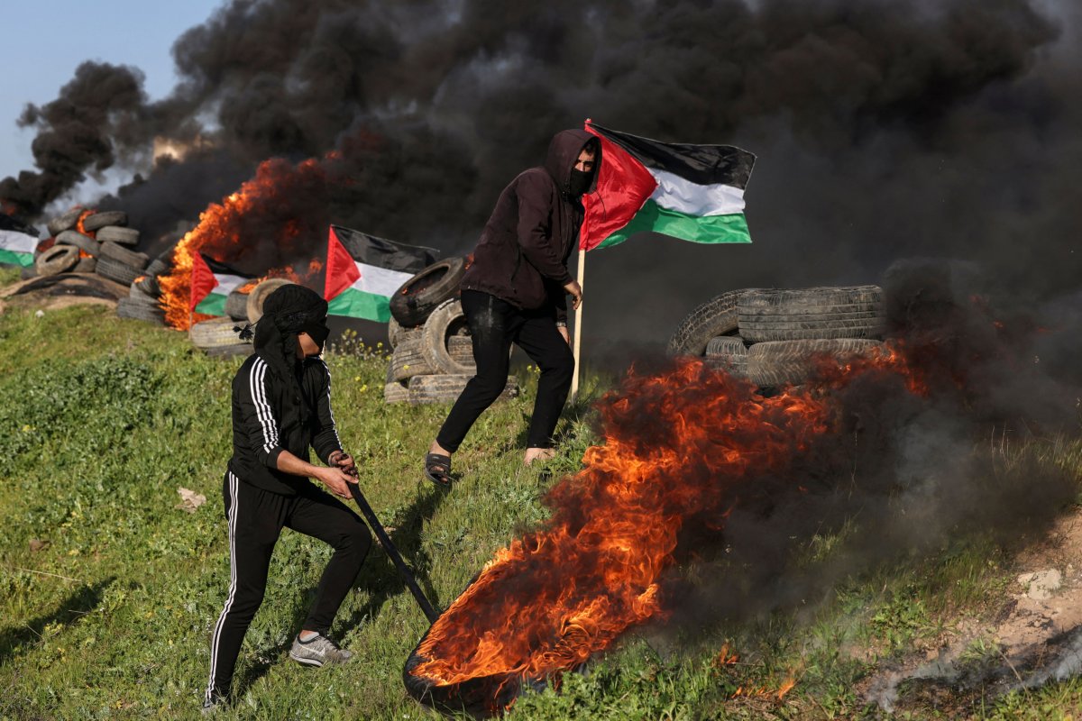 Palestinian youths burn tyres during a protest