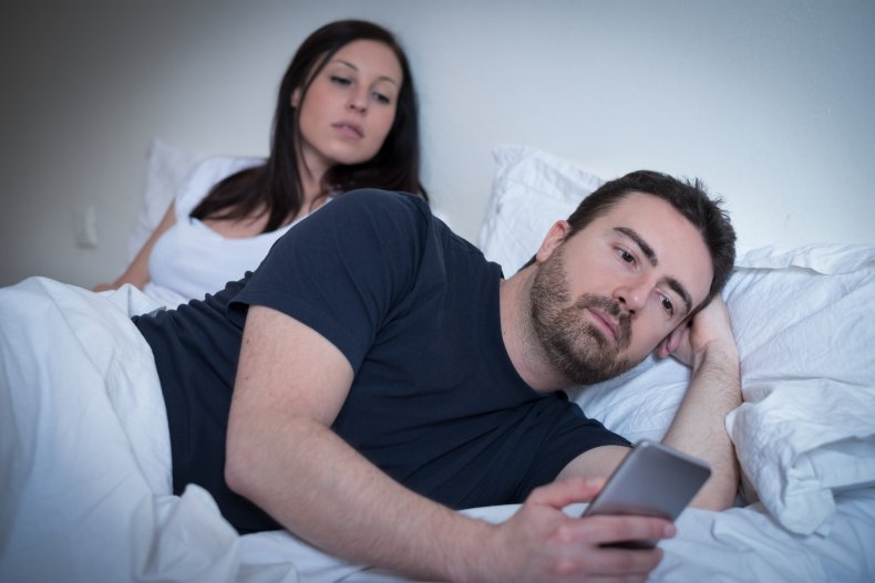 Woman looking over boyfriend's shoulder at phone