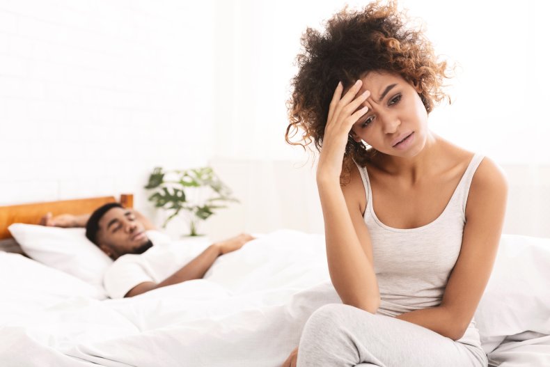 Unhappy woman sitting on bed