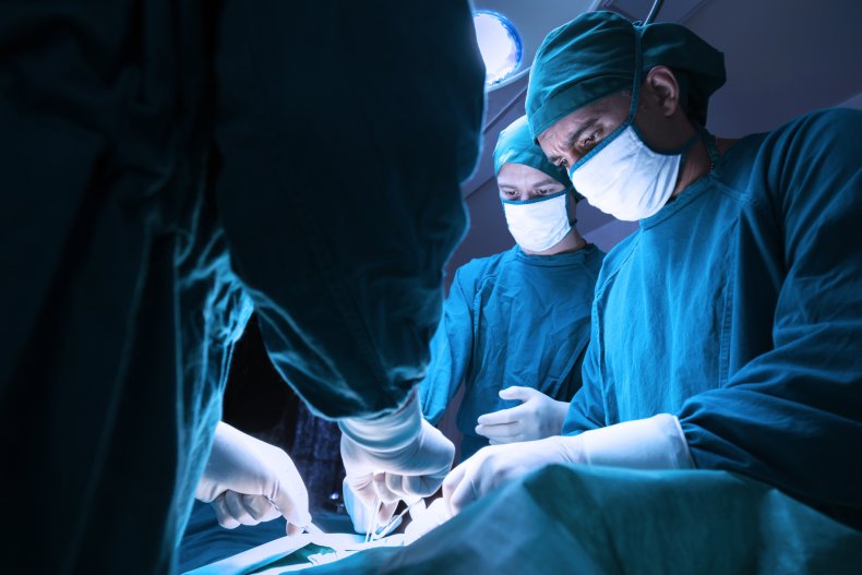 Three surgeons operating on a patient. 