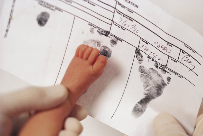 Baby's foot being stamped on birth certificate.