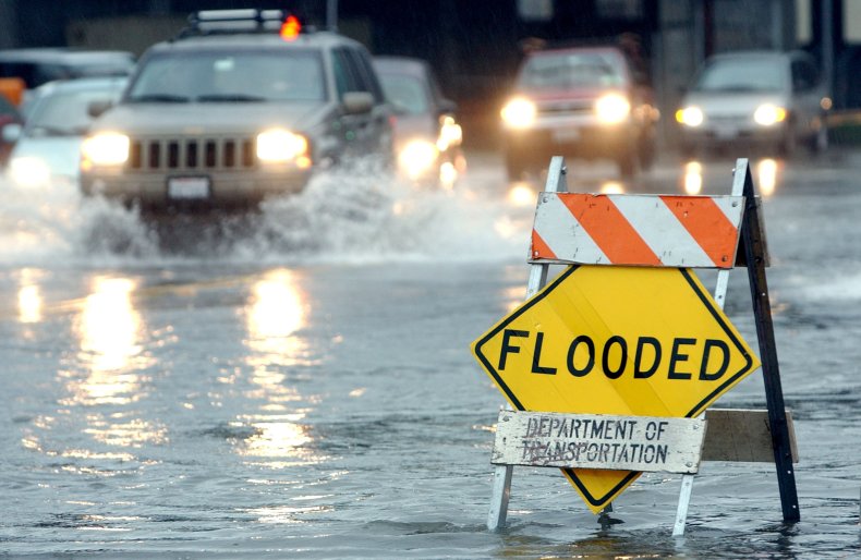 Cars drive through flooded California road