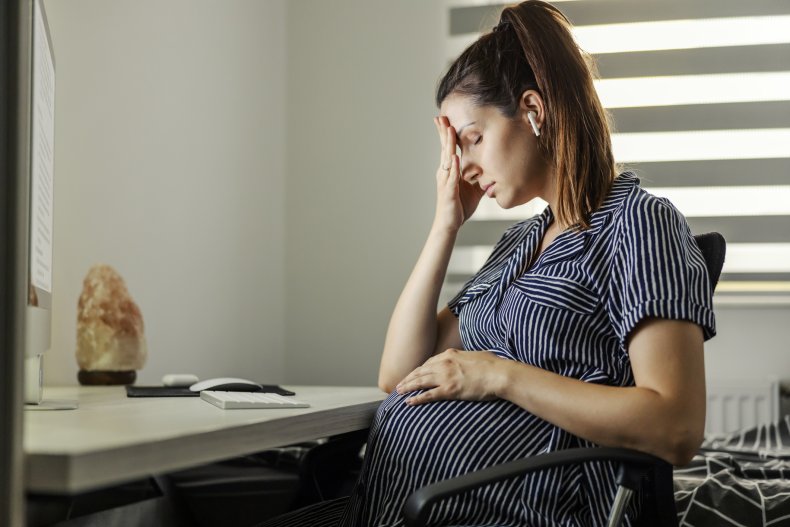 Stressed pregnant woman working from home