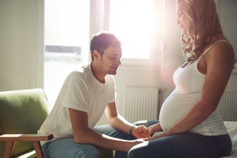 A man holding his pregnant wife's hands