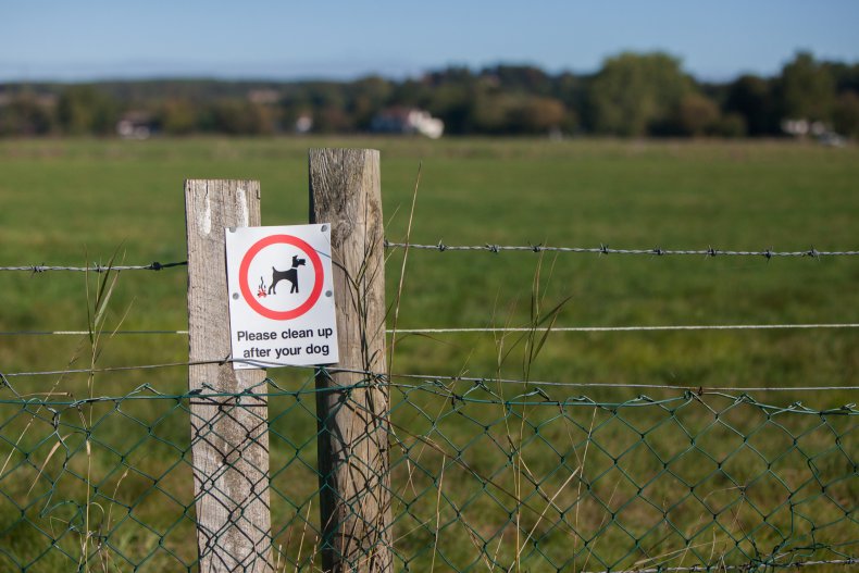 Barbed wire fence with dog poo sign.