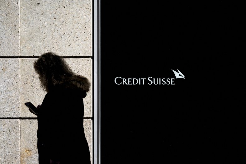 A woman walks past Credit Suisse bank