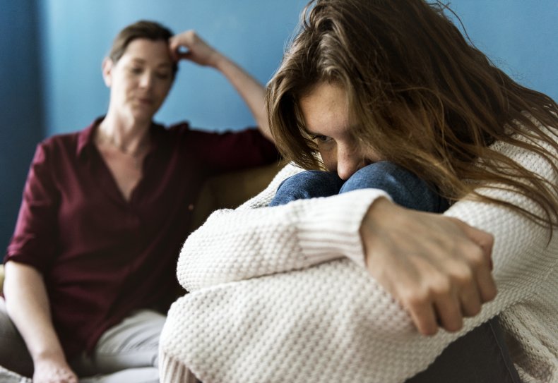 Upset teen with arms wrapped around knees
