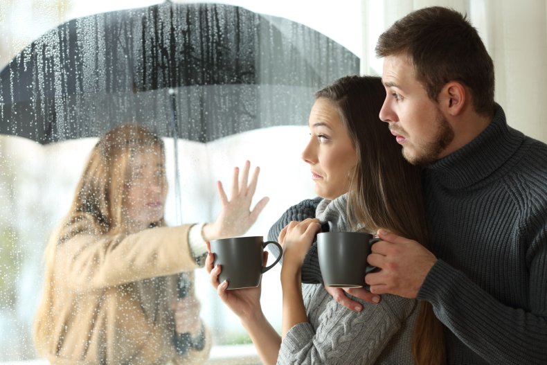 Femmes sous la pluie atteignant le couple à l'intérieur.