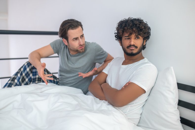 A man ignoring his boyfriend in bed