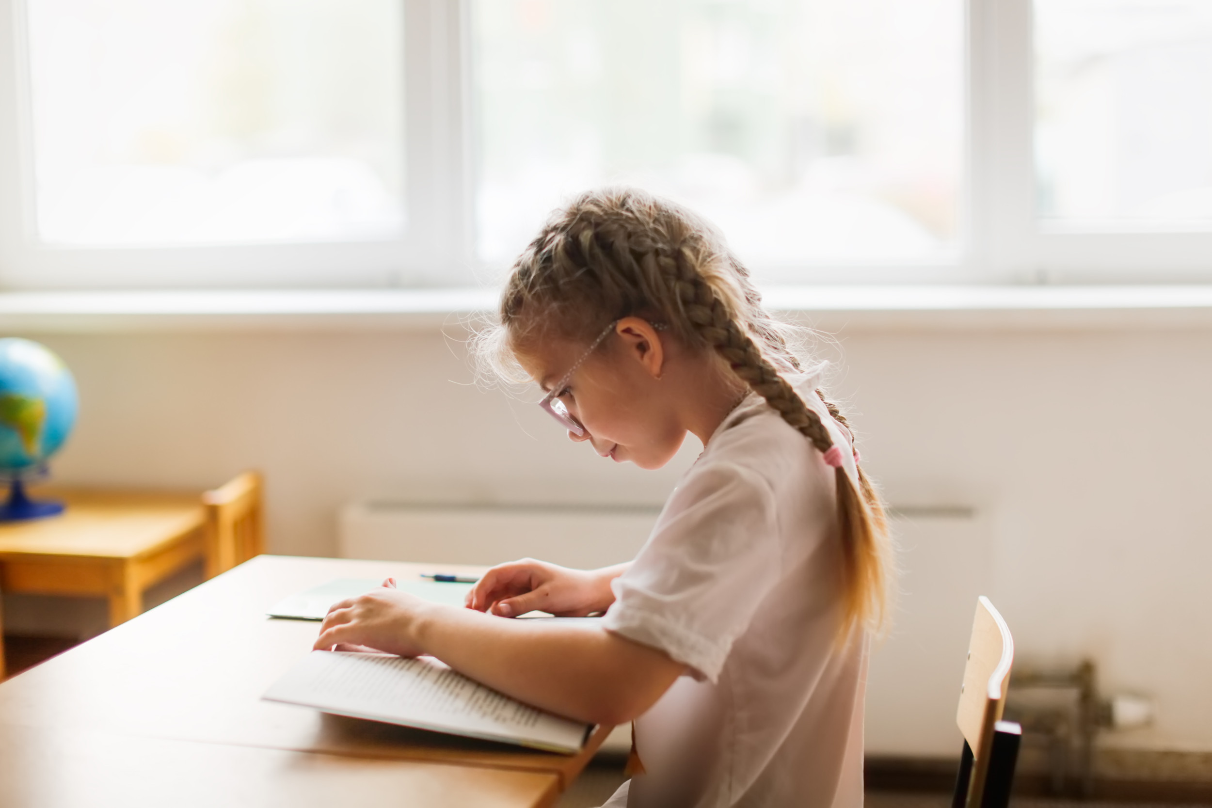 Child reading a textbook in school