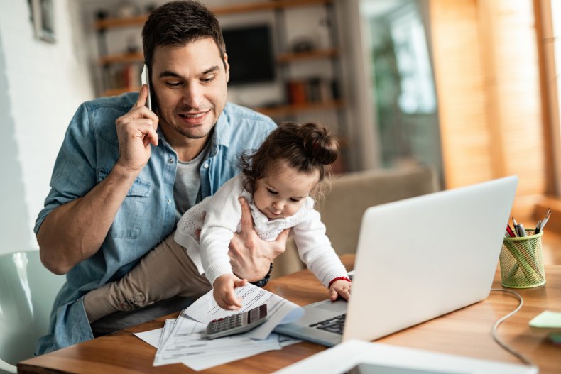 Man holding a baby, working from home.