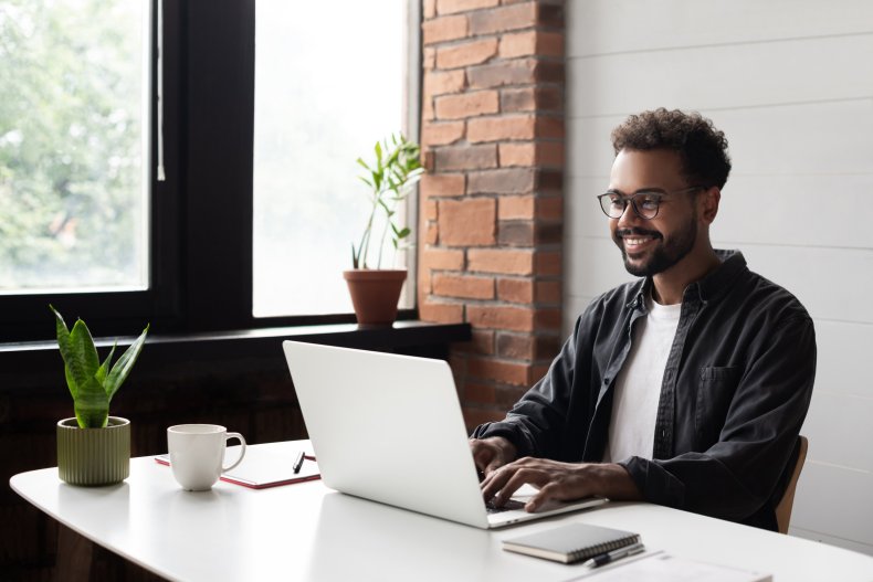 Man smiling during a video call on a laptop.