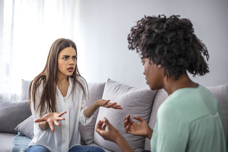 Two female friends arguing on a sofa