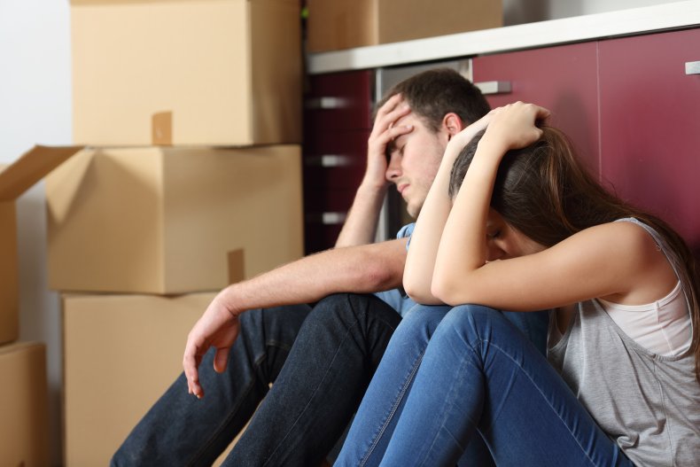 Evicted couple sitting amongst packing boxes
