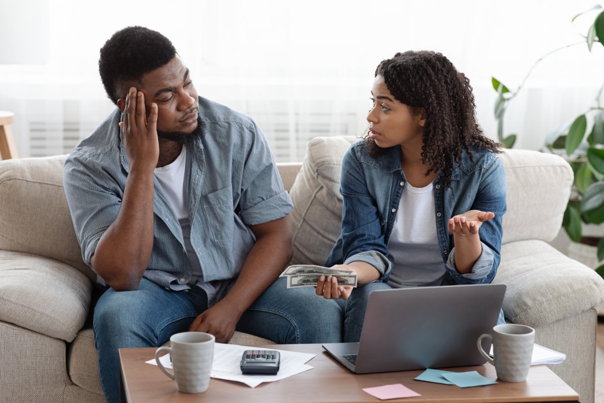 Couple looking at laptop discussing finances. 
