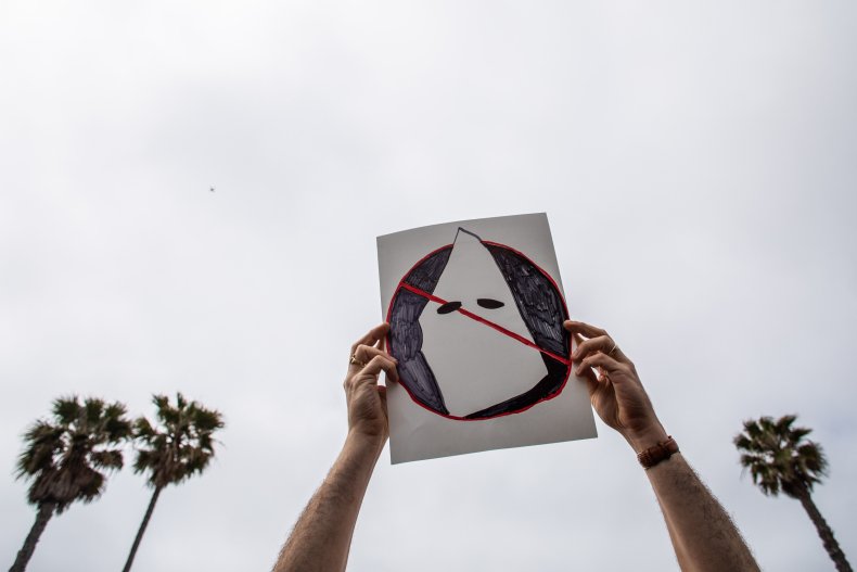 A man holds anti-KKK sign