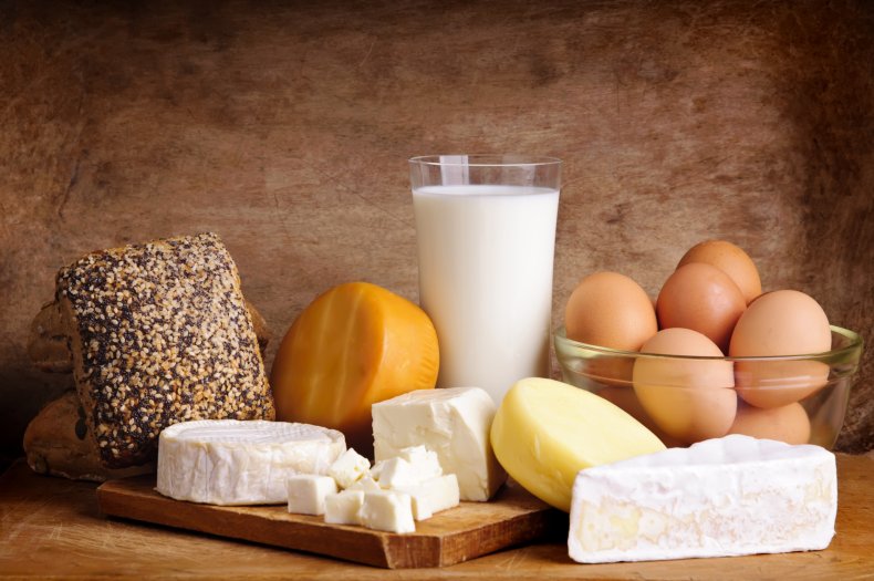 Eggs, cheese, milk, bread on table.