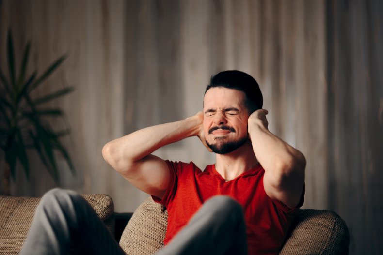 A man with hands over his ears