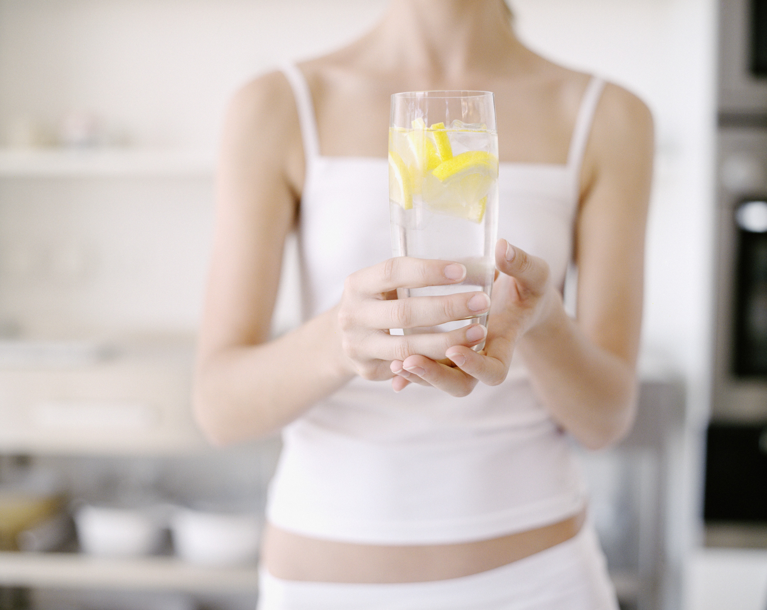 Пить стакан воды натощак. Девушка со стаканом воды. Девушка пьет воду с лимоном. Девушка с лимоном. Утро девушка со стаканом воды.