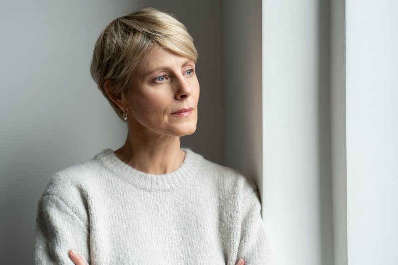 Depressed older woman staring out of window
