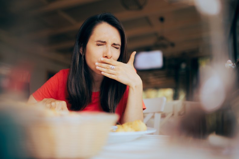 A nauseous pregnant woman at dinner table