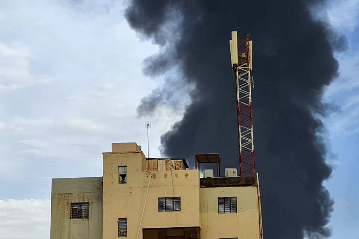 Black smoke billows behind buildings 