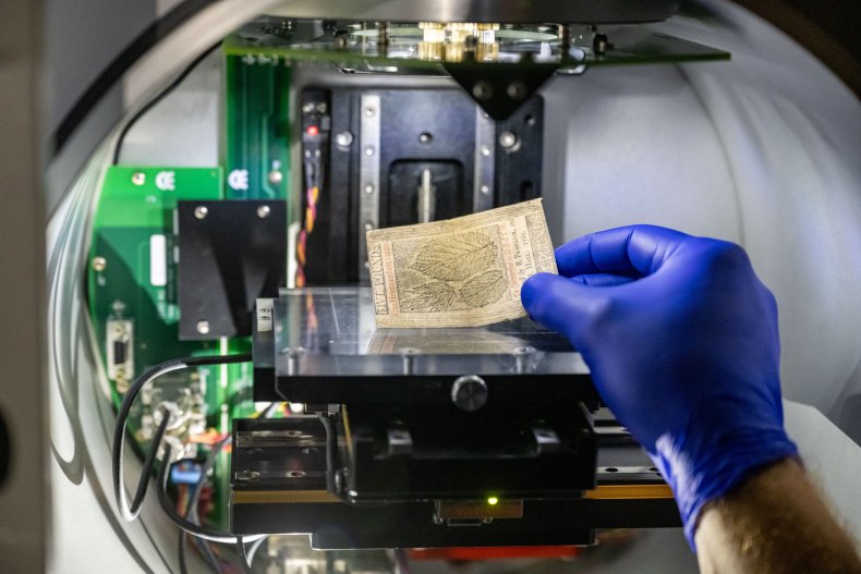 A researcher holding an old paper note