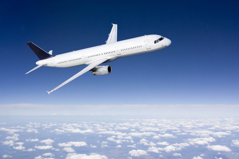 Plane flying above clouds under blue sky.