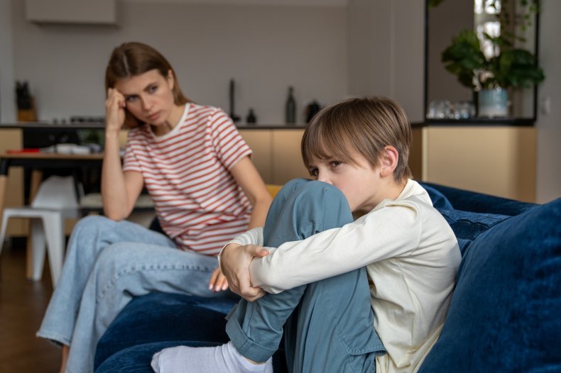 Teenage boy looking upset beside a woman.