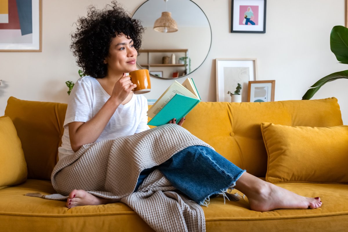 Woman reading a book while drinking tea