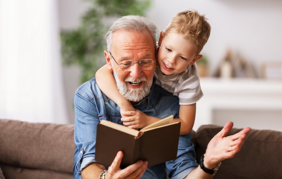 Grandfather reading a book to his grandson