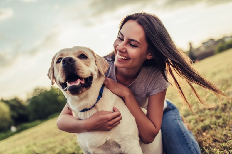 Donna che abbraccia Labrador fuori