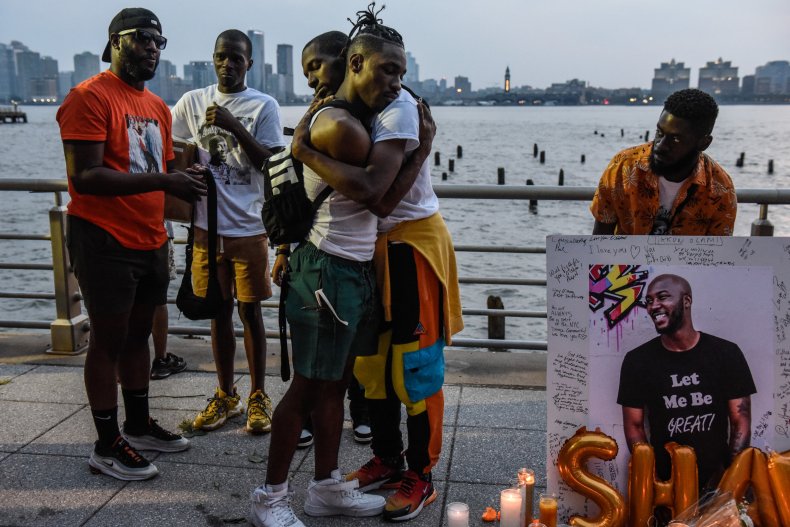 People hug next to a makeshift memorial