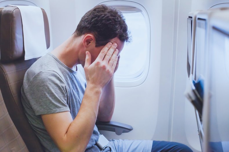 Passeggero che sembra sconvolto sull'aereo.