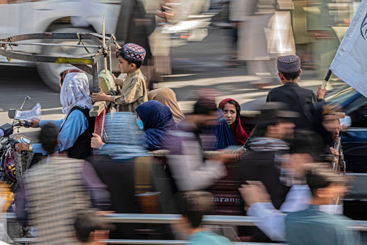 Afghan women and children ride a three-wheeler 