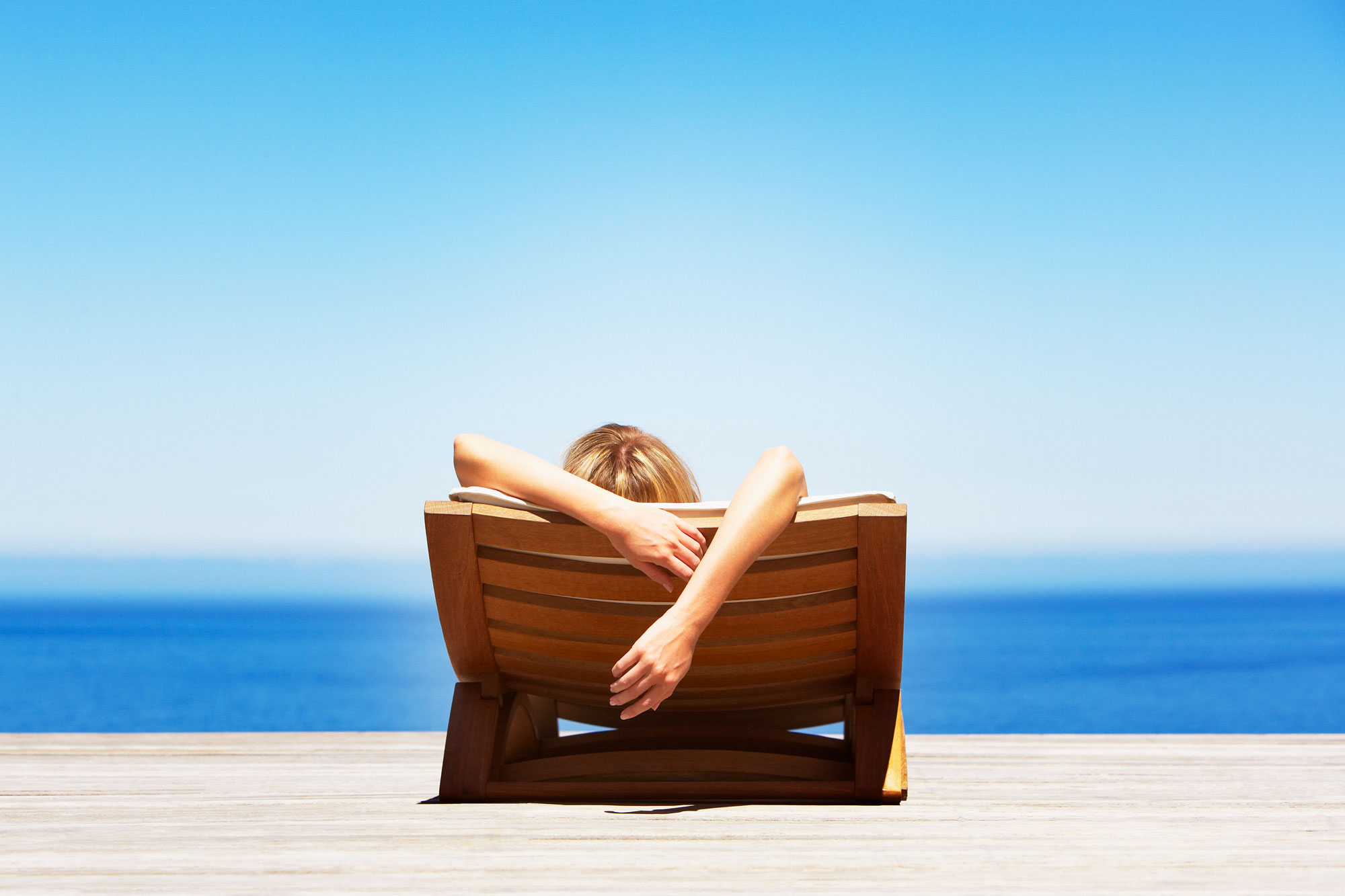 Расслабленный отдых. Девушка на шезлонге. Девушка на берегу моря. Девушка на шезлонге с книгой. Отпуск с книгой.