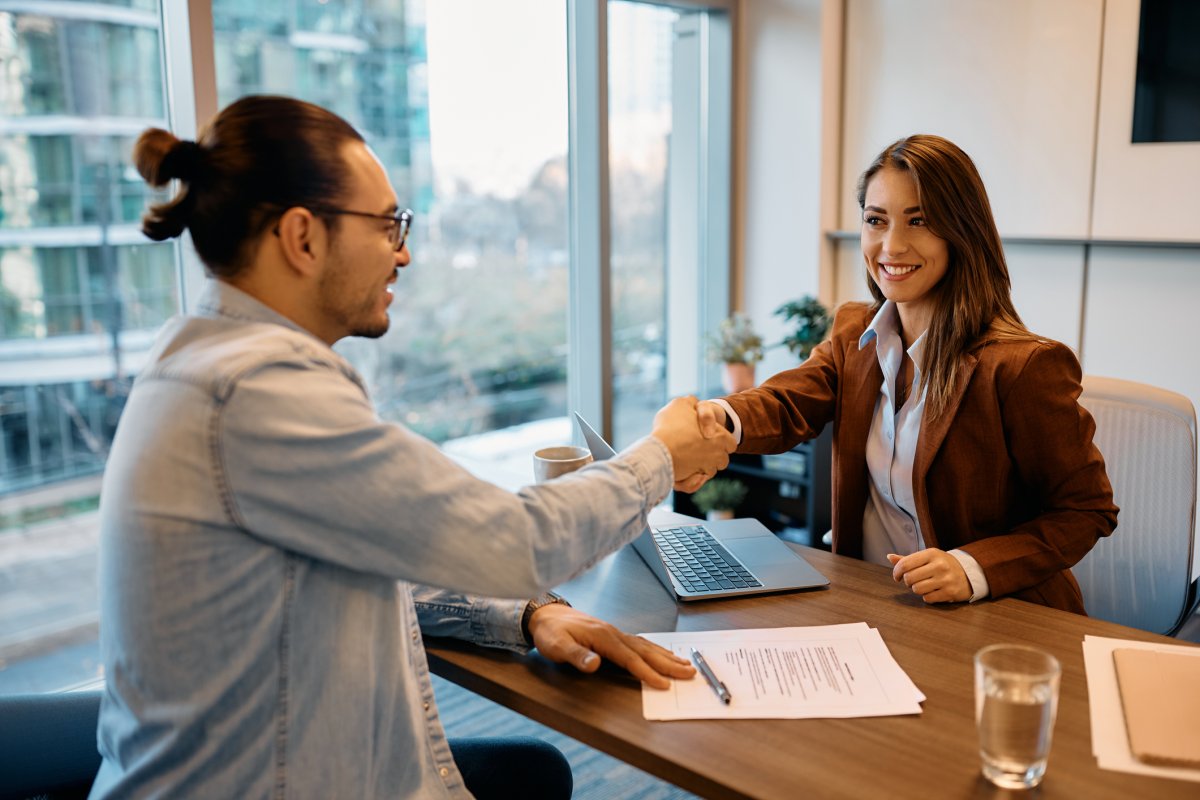 Businesswoman shaking hands with job candidate