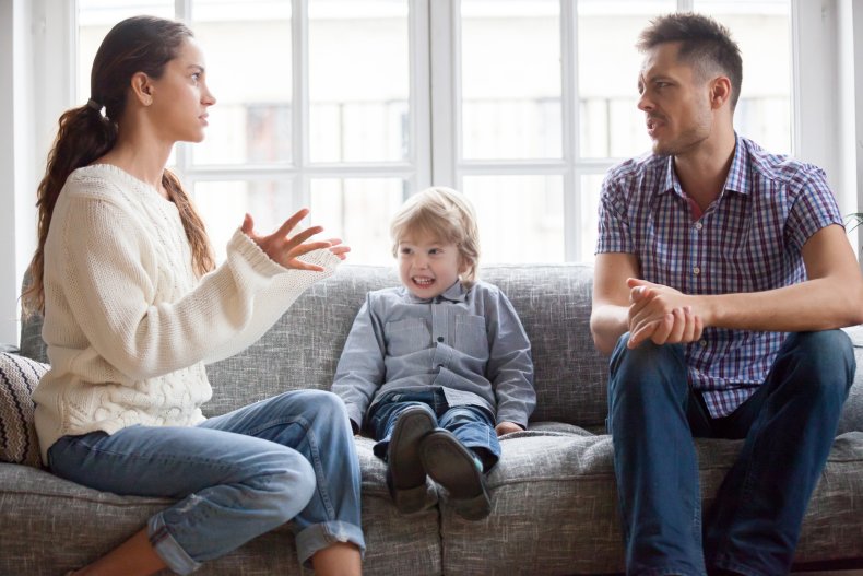 Couple arguing on couch, child seated between.