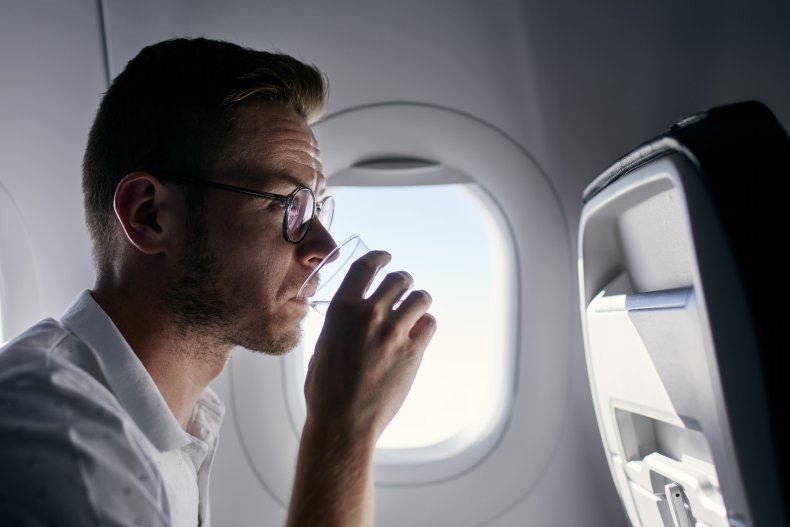 Man drinking water on plane.
