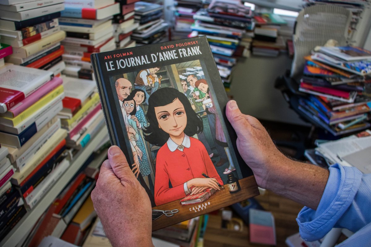 A man holds Anne Frank graphic novel