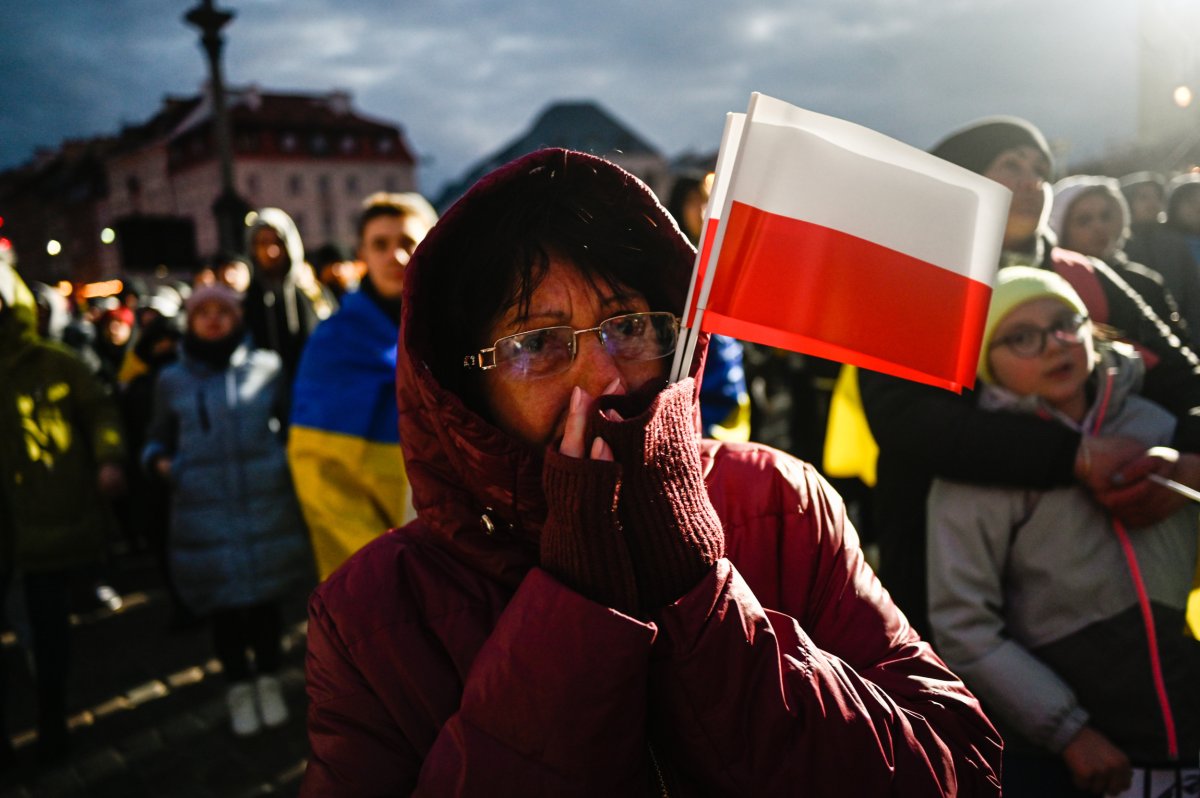 Woman holding Polish flags in Warsaw