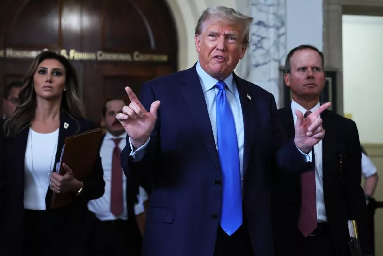 Donald Trump dengan gestur marah menunjuk ke luar pengadilan saat dia berbicara kepada media saat istirahat makan siang pada hari pertama persidangan penipuan perdata di Mahkamah Agung Negara Bagian New York pada 2 Oktober 2023, di New York City. Dia lebih pendiam di dalam ruang sidang.