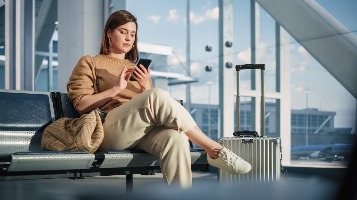 Woman looking at phone at airport. 