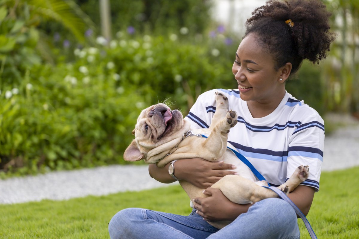 A woman carrying her dog