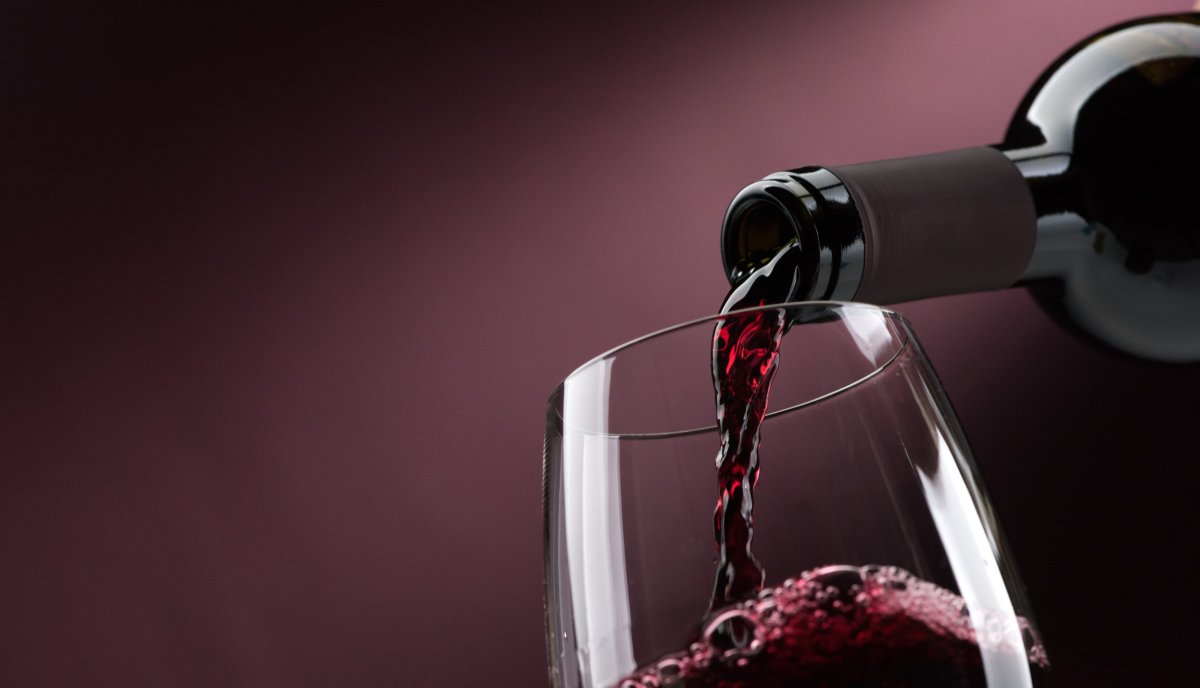 A glass of red wine is poured