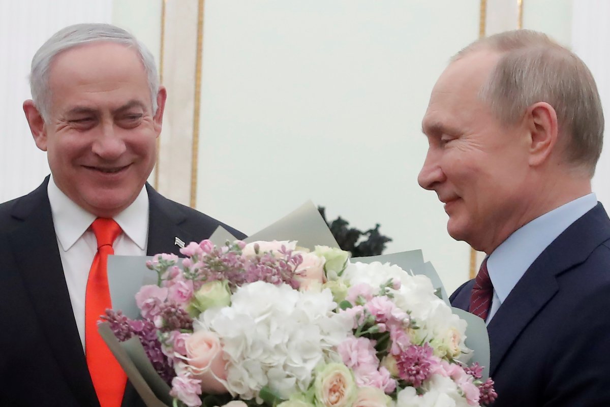 Russian President Vladimir Putin holds flowers