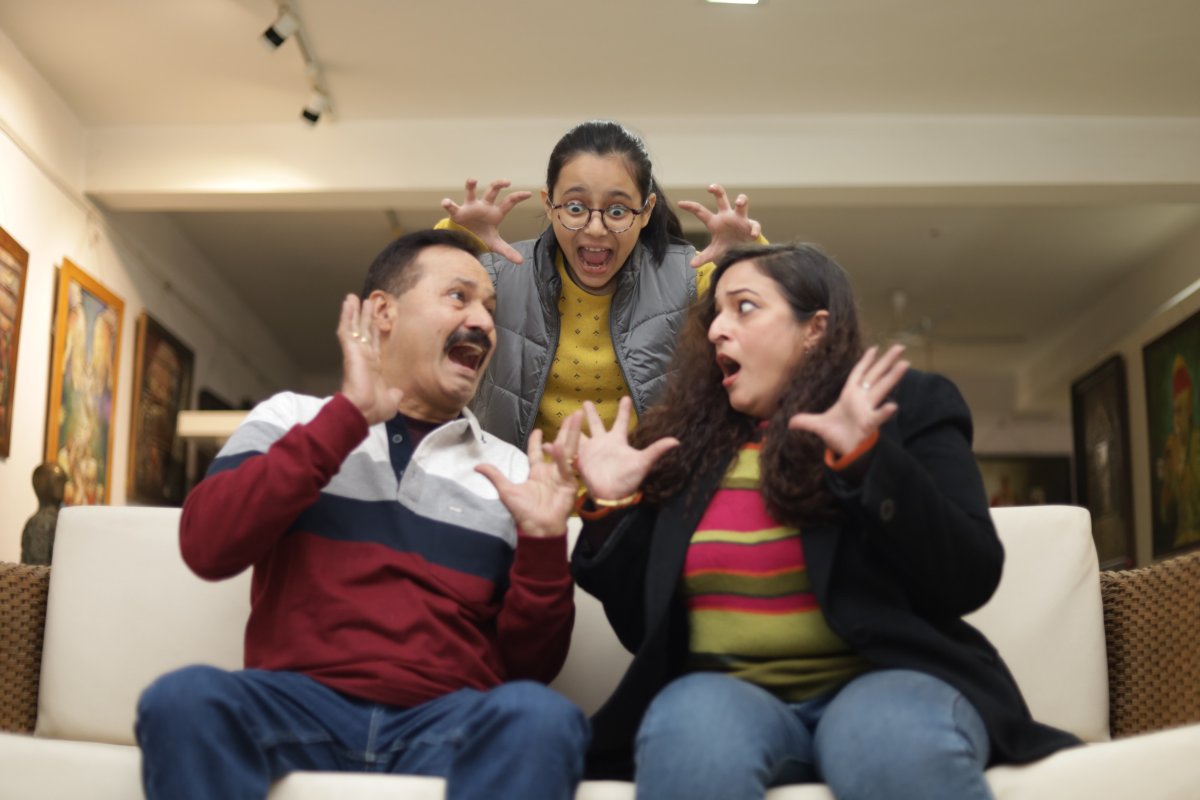 Family looking scared on couch at home.