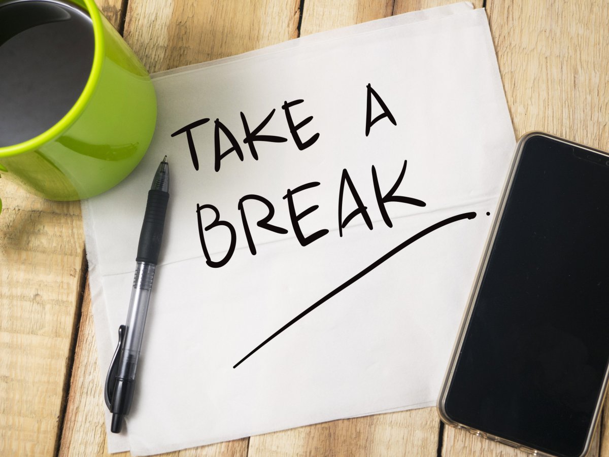 Paper saying "take a break" on desk.