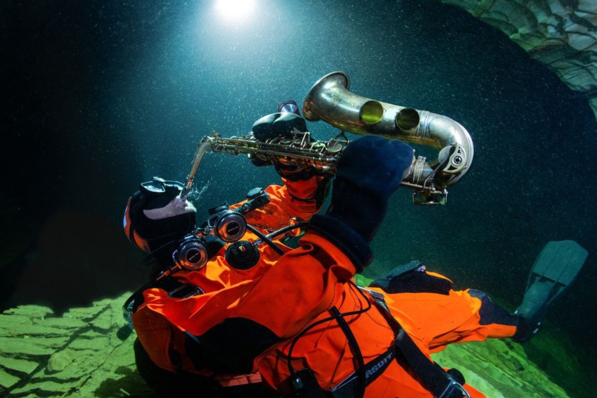 Diver playing saxophone under water.