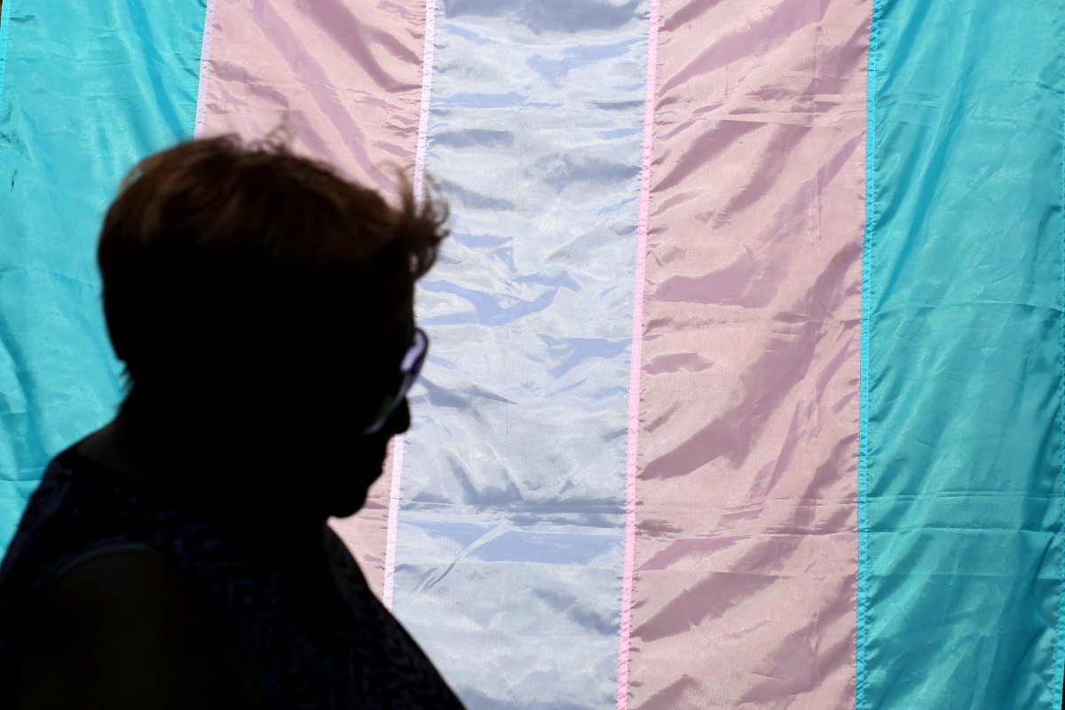 A person walks past a Transgender flag 